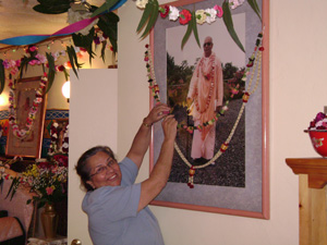 Diksavati Didi garlanding Srila Gurudev's picture in the Temple room.