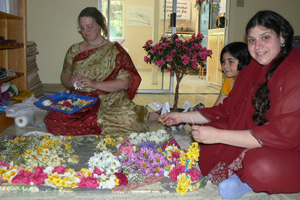 Laxmipriya Didi, young Radha Dasi and her mother, Para Didi create beautiful garlands for Srila Gurudev and Their Lordhips Sri Sri Guru Gauranga Gandharvika Giridhari.