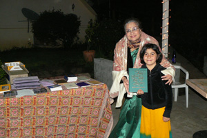 Diksavati Didi gets assistance from young Radha Dasi at the book table.