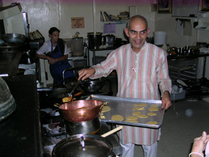 The bhoga offering is almost done as the devotees happily prepare the feast while listening to the lecture.