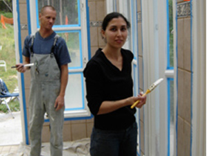 Giridhari Prabhu and Sara painting the trim around the windows.