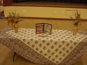 An altar with flowers and a picture of Srila Gurudev and our Lordships Sri Sri Guru Gauranga Gandharvika Giridhari.