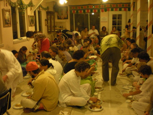 Everybody happily honours Prasadam.