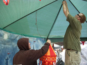 Setting up our booth and adjacent Sankirttan tent at the festival.  Ratan Krishna and Ramachandra Prabhus arrange the decorations.