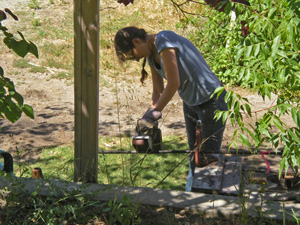 Sushila Devi Dasi helps with the pipes.