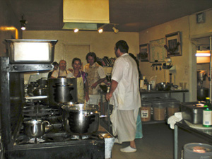 Everybody in the kitchen is happily engaged in some service.