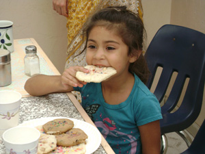 Kumari Shivani happily eats the cookie she made. Yum!