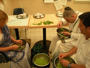 Srimati Madhumati Didi, Anantarupa and Nayananda Prabhus help prepare fresh peas for future offerings.