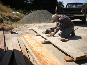 Sarva Bhavana Prabhu cuts the boards that will be used to  make the forms for the next wall.