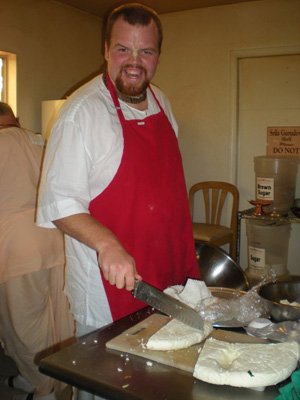 Ramachandra Prabhu returning from India engages happily in the kitchen seva.