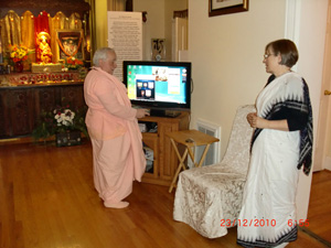 Srimate Kumkum Didi looks on, ever attentive to the needs of the devotees.